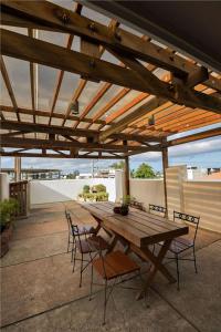 uma mesa de madeira e cadeiras sob uma pérgola de madeira em Abozza Resort em Boracay