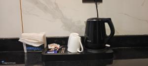 a black coffeemaker sitting on a black counter at Countryside Cottage Gulmarg in Tangmarg