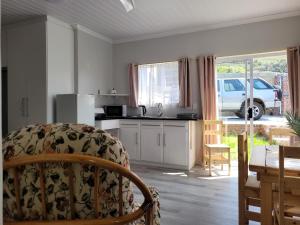eine Küche mit einem Tisch und einem Stuhl in einem Zimmer in der Unterkunft Heuning Nessie in Bredasdorp