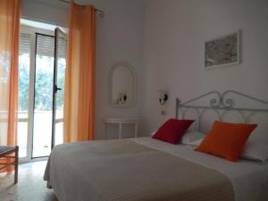 a bedroom with a bed with two red pillows at Hotel Europa in Ischia
