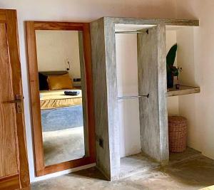 a door to a room with a bed and a mirror at Pranaya Villa in Hiriketiya