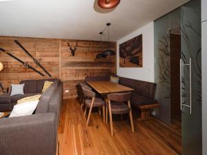 een woonkamer met een tafel en een bank bij Kitzb heler Alpenlodge Top A6 with private panoramic sauna in Mittersill +25 foto's