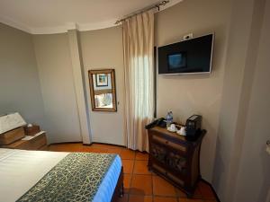 a bedroom with a bed and a television on the wall at Beyond The Blue Horizon Boutique Bungalows in Haad Chao Phao