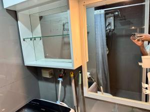 a person taking a picture of a bathroom mirror at Executive Suite Air Residence Style Comfort Makati 300 Mbps in Manila +32 photos