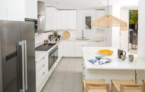 a kitchen with white cabinets and a stainless steel refrigerator at Villa Sea Escape in Brusje