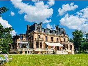 a large house with a grassy field in front at Château de Crenille -Appartements in Chaumes-en-Brie