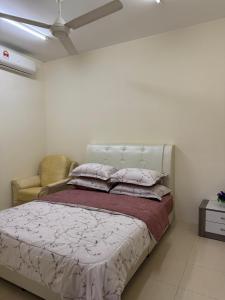 a bedroom with a bed and a chair at Adawiyah Guest House, Gambang in Gambang