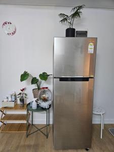 ソウルにあるHongdae ssuny houseの植物のある部屋にあるステンレス製の冷蔵庫