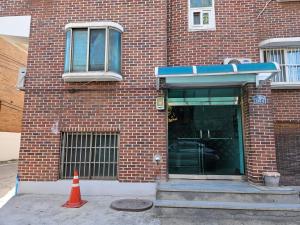 ソウルにあるHongdae ssuny houseのレンガ造りの建物前のオレンジ色の円錐