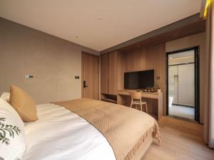 Krevet ili kreveti u jedinici u okviru objekta Qingdao Wushe Yujianshanju Tangchi Seaview Hotel