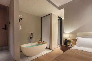 Krevet ili kreveti u jedinici u okviru objekta Qingdao Wushe Yujianshanju Tangchi Seaview Hotel