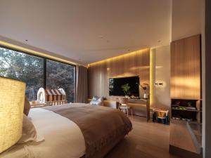 Krevet ili kreveti u jedinici u okviru objekta Qingdao Wushe Yujianshanju Tangchi Seaview Hotel