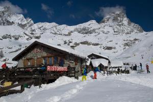 a group of people standing outside of a building in the snow at Hotel Baita Cretaz in Breuil-Cervinia