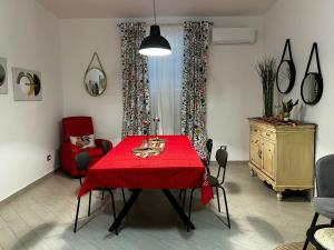 a dining room with a red table and a red chair at B&B Le Chicche di Lulu' in Borghetto