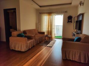 un soggiorno con due sedie e una finestra di Deluxe 2BHK for Families- Opp Whitefield Metro a Bangalore
