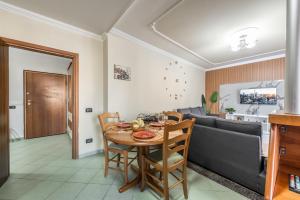 a dining room and living room with a table and a couch at Aria Apartment in Durrës