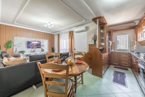 a kitchen and living room with a table and a couch at Aria Apartment in Durrës