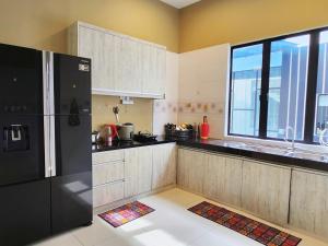 a kitchen with a black refrigerator and a window at Botani Double-Storey Haven 5B4B by verve 19pax in Ipoh +10 photos
