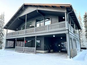 a large house with a balcony in the snow at Rukanmetsä, cottage, Ruka in Rukatunturi 