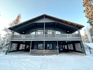 a large building with a balcony in the snow at Rukanmetsä, cottage, Ruka in Rukatunturi 