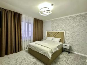 Un dormitorio con una cama y una ventana grande. en Karibi Complex, en Kyzylorda