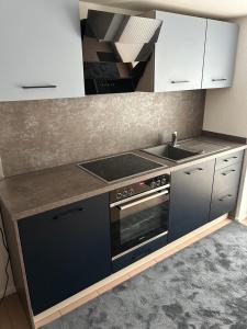 a kitchen with a stove and a sink at Ferienwohnung Schieferglück in Gründau +5 photos