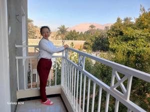 a woman standing on the balcony of a house at Valencia Villa & Rooms in Luxor