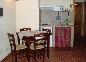 a kitchen with a table and chairs and a sink at La Casa Delle Cascate in Saturnia