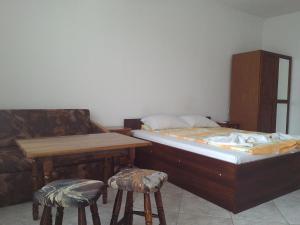 a bedroom with a bed and a table and two stools at Guest House Diamant in Sozopol
