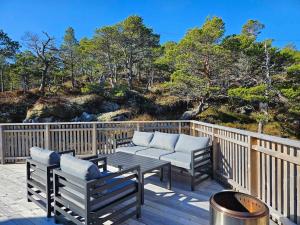 a deck with two chairs and a table and a grill at Large modern cabin with a spectacular view! in Grønningen