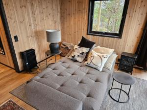 a living room with a large couch and a lamp at Large modern cabin with a spectacular view! in Grønningen