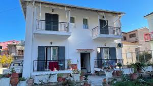 a white house with black windows and balconies at Katerina s House 1 in Nydri