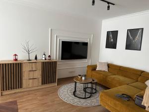 a living room with a couch and a flat screen tv at Celine Apartments in Lębork