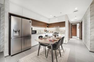una cucina con tavolo con sedie e frigorifero di FIRST CLASS 2BR Mesmerizing Creekfront Views a Dubai