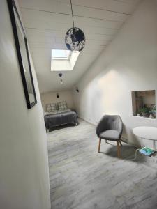 a living room with a bed and a chair at Le cocon de Veyre in Martres-de-Veyre +16 photos