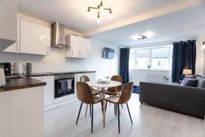 a kitchen and living room with a table and chairs at Commercial Road Apartments Central Location Wyvern Theatre in Swindon