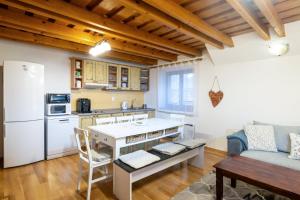 a kitchen with a table and a couch in a room at Apartmanica Fairy Tale, JASNÁ - SKI TÁLE- MÝTO POD ĎUMBIEROM, 3 apartments in 1 house, fireplace, free parking in Horná Lehota