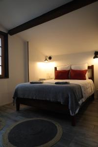 a bedroom with a large bed with red pillows at Maison Hordago Chambres d'hôtes in Sare