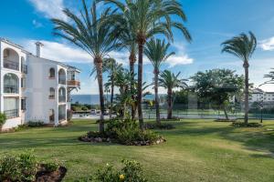 ミハスにあるCharming Mijas hideaway, sea views & parking by REMSの建物前のヤシの木が茂る芝生