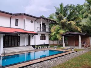 a house with a swimming pool in front of it at Tharan Villa - House in Colombo in Polgasowita