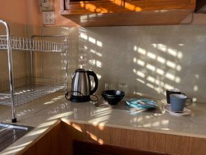 a kitchen counter with a tea kettle and cups on it at Tawan Shine in Chiang Rai