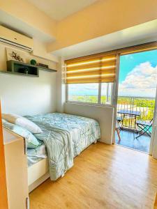 a bedroom with a bed and a large window at Casa de Amor in Kaybagal