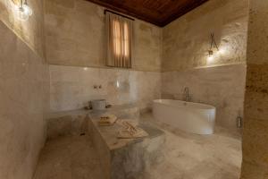 a large bathroom with a tub and a sink at Asmalı Konak Cave Suites of Cappadocia in Ürgüp