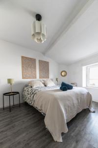 a white bedroom with a large bed and a chandelier at Grande Maison Clermont - Appartements centre ville in Clermont-Ferrand