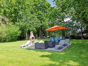 a group of chairs and an umbrella on a lawn at Maison spacieuse et conviviale à Saint-Alban avec jardin in Saint-Alban