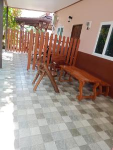 een rij houten stoelen en een bank op een tegelvloer bij Lamai Home 2 in Ko Yao Noi +1 foto
