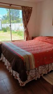 a bed in a room with a large window at Costa Monkul - Carahue y Puerto Saavedra in Nahuentúe