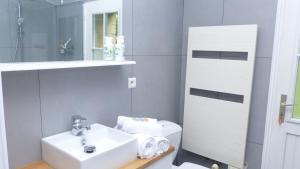 a bathroom with a white sink and a toilet at Maison familiale a 700m de la plage de Kervillen in La Trinité-sur-Mer