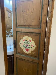 a wooden door with a flower design on it at Viscri 143 in Viscri