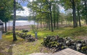 a pile of rocks in a field next to a body of water at Amazing Home In Perstorp With Sauna in Perstorp +13 photos